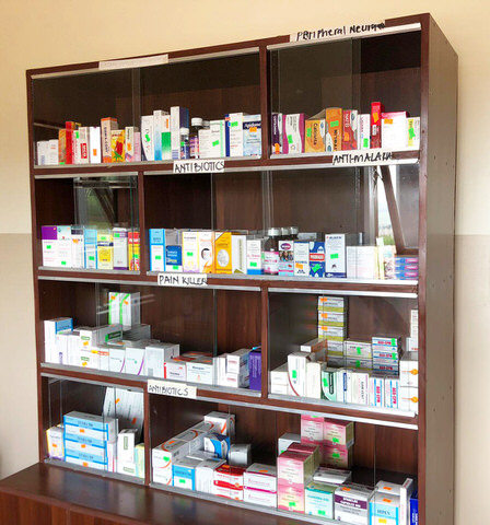 Ein sortierter Schrank zur Arzneimittellagerung in der Apotheke der Lamc Clinic in Jinja, Uganda